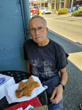 Gary contemplates a Maple Bar Man at the Poulsboe Bakery.